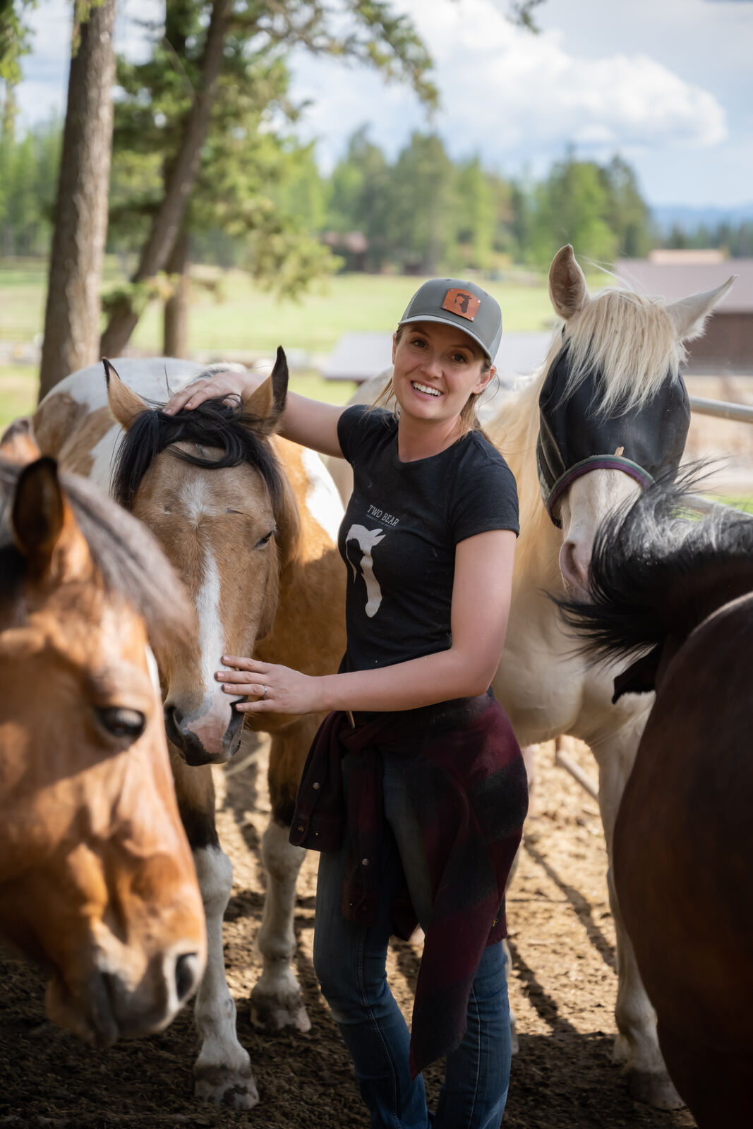 Kat standing among a group of loose horses in a pasture